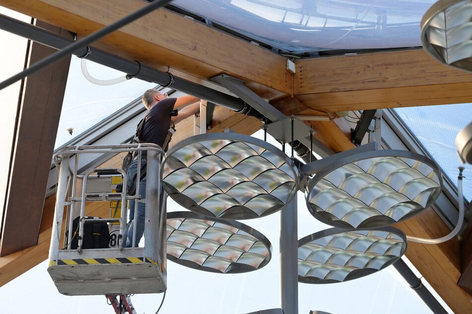Sicherheitsrelevant: In luftiger Höhe unterm Hallendach tauscht eine Fachkraft den Stellmotor des Dachfensters aus.
