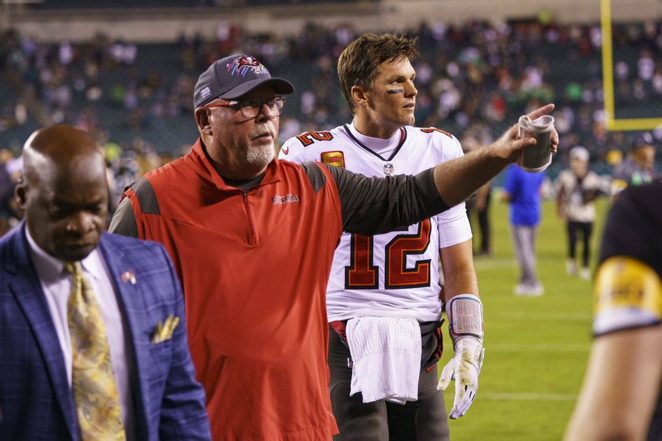 Buccaneers head coach Bruce Arians (c) heads off the field with quarterback Tom Brady (r).