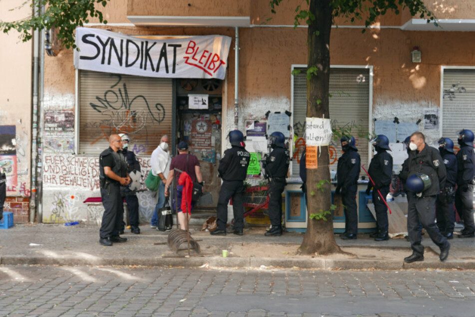 Gerichtsvollzieher Frank Bossin (54) steht mit Polizisten am Freitagmorgen vor dem "Syndikat" in Berlin-Neukölln.