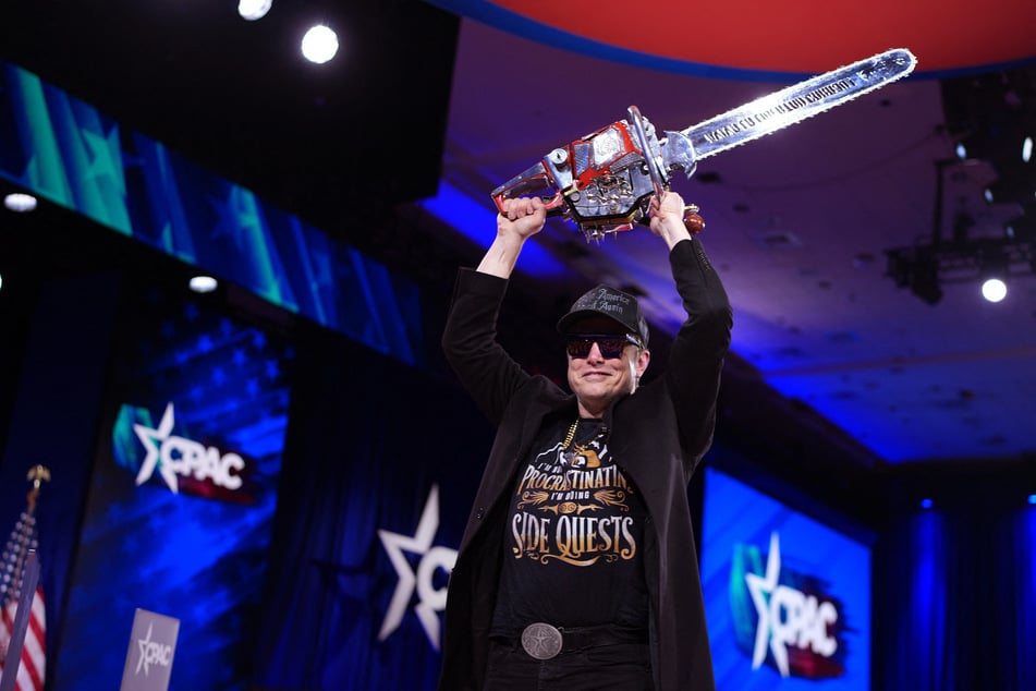 CEO of Tesla and SpaceX Elon Musk leaves the stage holding a chainsaw after speaking at the Conservative Political Action Conference (CPAC) at the Gaylord National Resort Hotel And Convention Center on Thursday in Oxon Hill, Maryland.