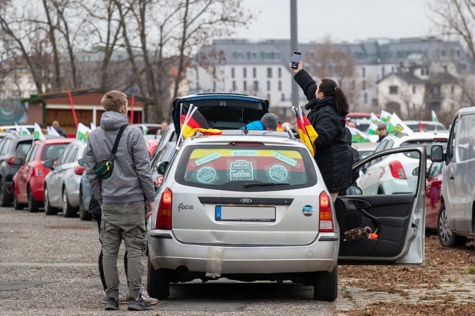 Kurz vor dem Start eines Querdenker-Autokorsos durch die Innenstadt von Dresden haben sich mehrere Autos auf einem Parkplatz versammelt. Mit dem Korso soll gegen die Corona-Maßnahmen protestiert werden.