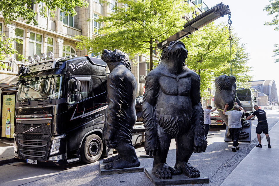 Die mehr als drei Meter großen Affen-Skulpturen des chinesischen Künstlers Liu Ruowang werden von Technikern in der Hamburger Mönckebergstraße aufgestellt.