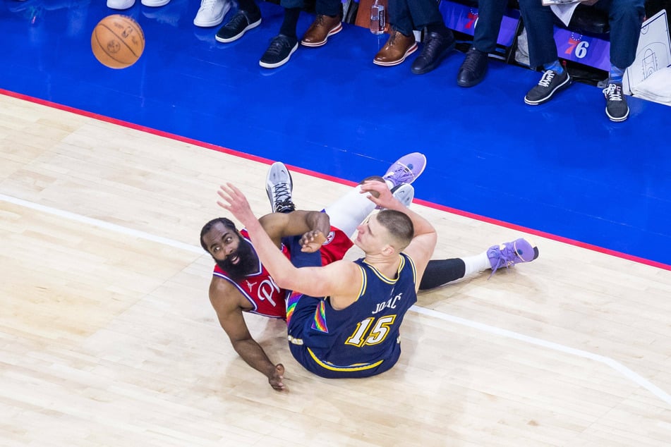 James Harden and Nikola Jokić tussle for the ball.