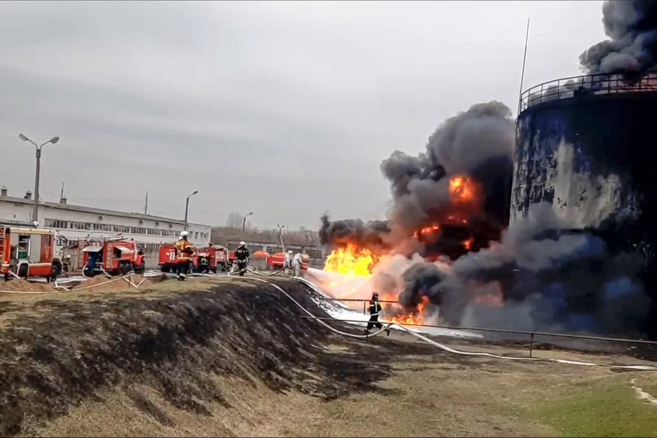 Feuerwehrleute arbeiten an der Brandstelle eines Öldepots.