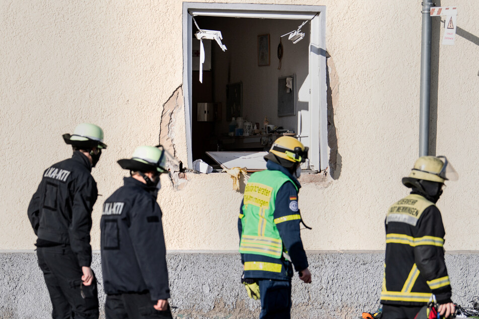 Einsatzkräfte des Landeskriminalamts und der Feuerwehr gehen an einer Rettungswache vom Bayerischen Roten Kreuz vorüber, in der es zu einer Explosion gekommen war.