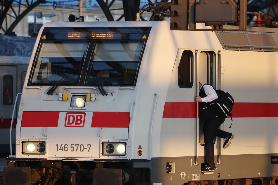 Ein Lokführer steigt am Kölner Hauptbahnhof in einen Triebwagen der Deutschen Bahn.
