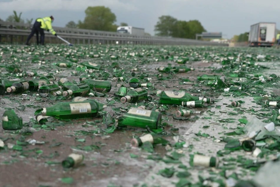 Zerstörte Bierflaschen liegen auf der Autobahn.
