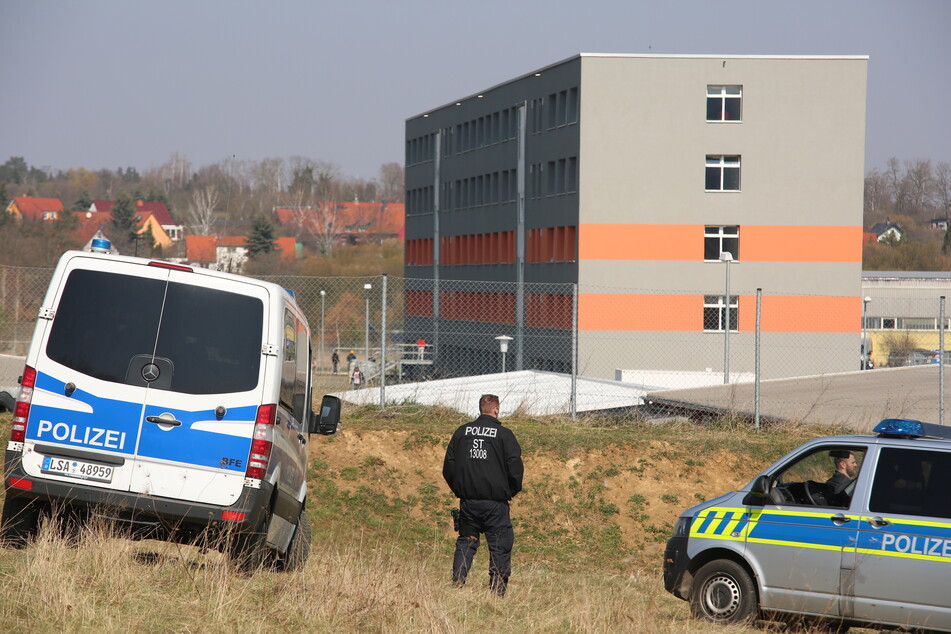 Polizisten stehen vor der Zentralen Anlaufstelle für Asylbewerber des Landes Sachsen-Anhalt in Halberstadt. Die Einrichtung steht unter Quarantäne.