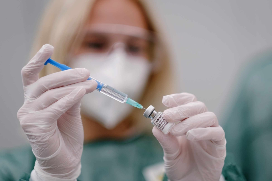 Eine Mitarbeiterin im Gesundheitswesen zieht im Impfzentrum eine Spritze mit dem Covid-19-Impfstoff auf.