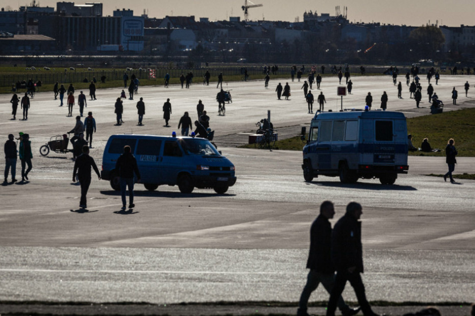 Polizeiwagen fahren zwischen Spaziergängern auf dem Tempelhofer Feld. (Symbolbild)