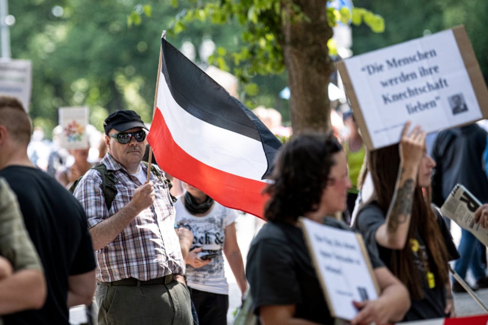 Bei einer Demo in Berlin am Samstag trägt ein Teilnehmer eine Flagge des Deutschen Reiches.