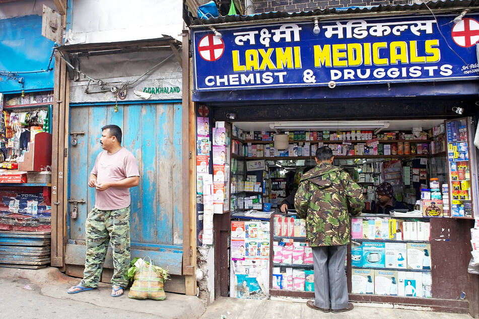 Ein Mann steht an einer Apotheke in Indien. (Symbolbild)