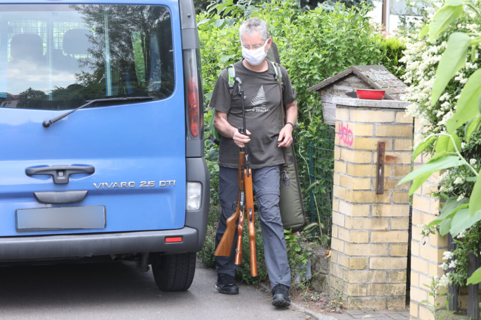 Die Einsatzkräfte prüfen die gesammelten Waffen aus dem Haus.