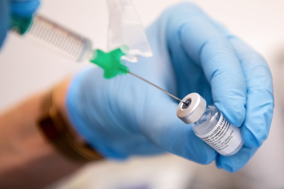 Bayern, Gauting: Eine Klinik-Mitarbeiterin zieht den Covid-19 Impfstoff von Biontech/Pfizer für eine Impfung auf eine Spritze.