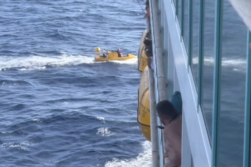Nach einer Stunde kehrt das Rettungsboot zum Kreuzfahrtschiff der "Royal Caribbean" zurück. Noch können die Passagiere nicht ausmachen, ob die von Bord gegangene Frau wohlauf ist.