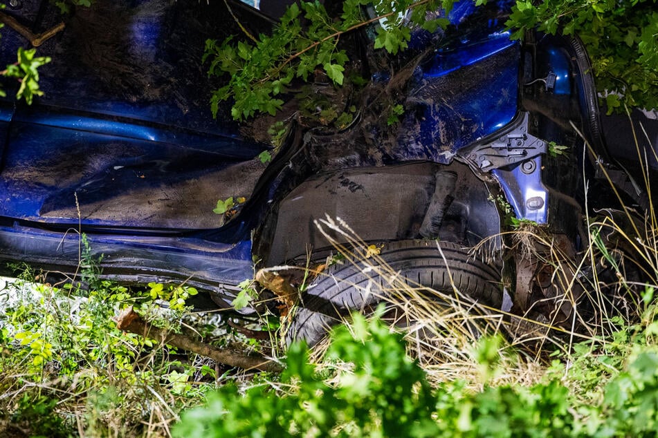 Kaum zu erkennen liegt der stark beschädigte VW Polo im Gebüsch neben der Autobahn.