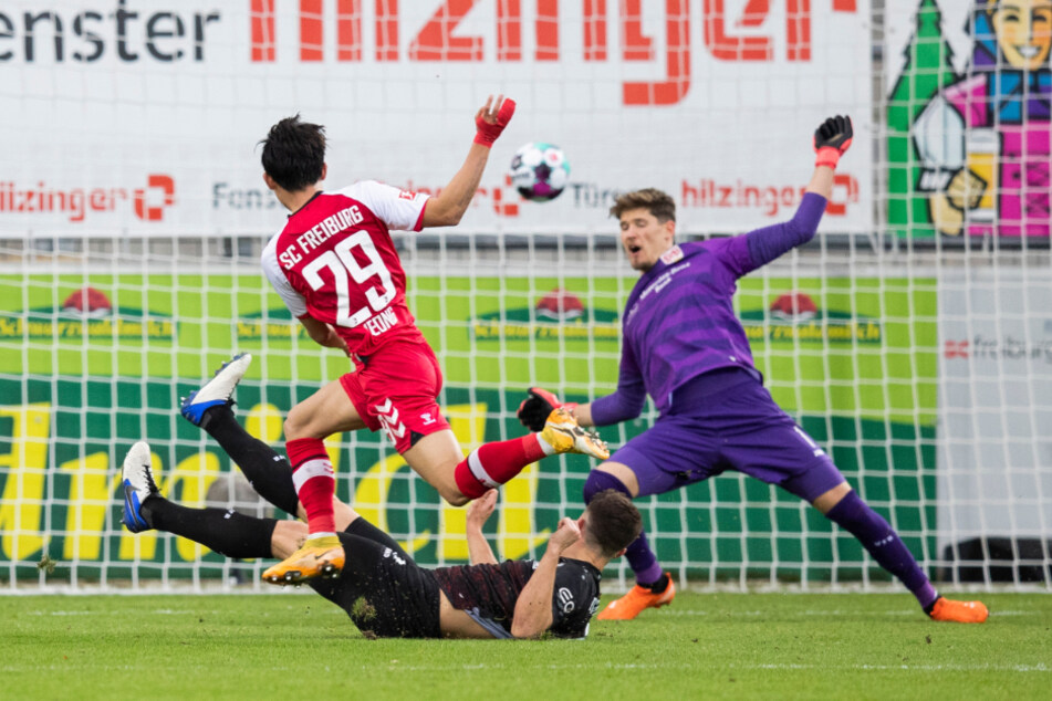 Freiburgs Woo-Yeong Jeong (vorne) überwindet VfB-Keeper Gregor Kobel (r.) und erzielt das 2:1 für den SC.