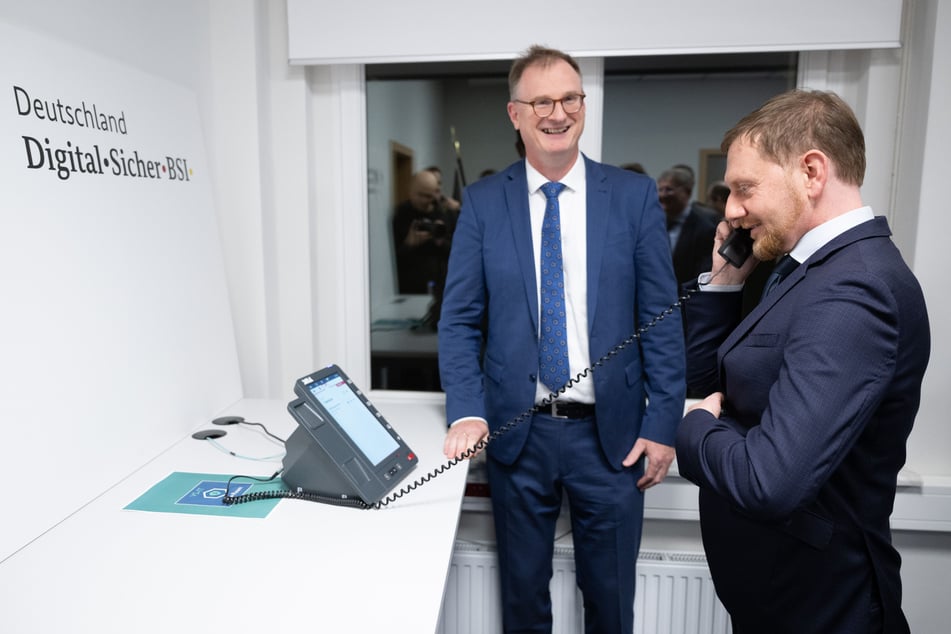 Funktioniert ganz einfach: Günther Welsch (57, l.) vom BSI erklärt Sachsens MP Michael Kretschmer (49, CDU), wie das abhörsichere Telefon zu benutzen ist.