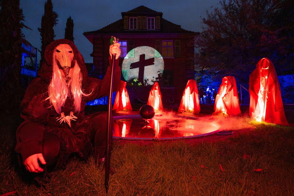 Fünf illuminierte Wächter und eine Monster-Darstellerin verzieren den Garten des zu einem Halloween-Haus dekorierten Wohnsitzes der Familie Reisgies in Frankfurt.
