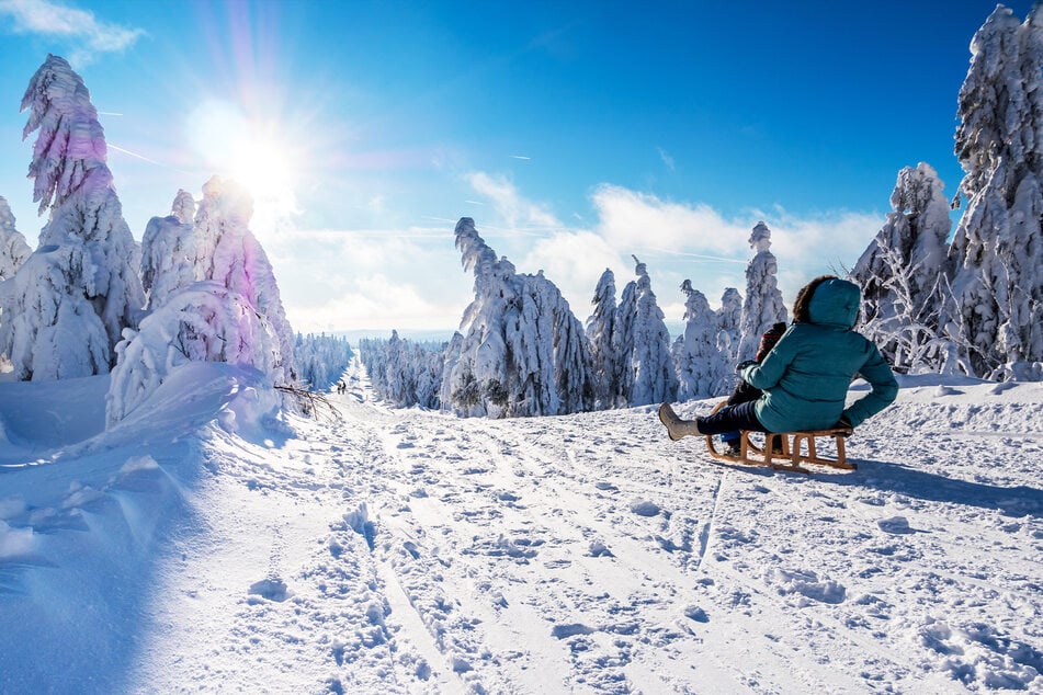 A woman tobogganing with her child (stock image).