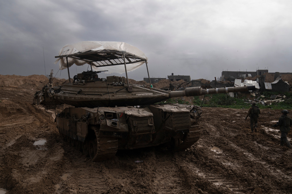 Israelische Soldaten gehen während der Bodenoffensive an einem Panzer in Chan Junis vorbei.