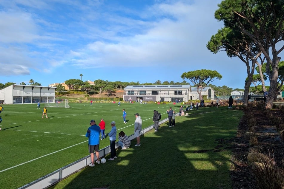 Rund 25 Fans stehen am Trainingsplatz.