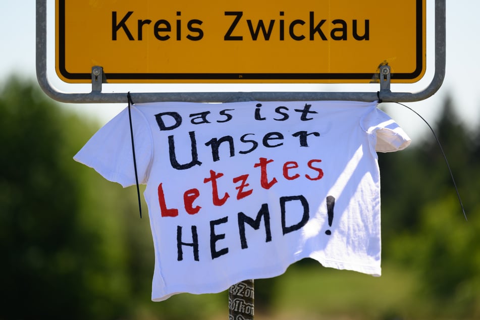 Ein T-Shirt mit der Aufschrift "Das ist unser letztes Hemd" hängt an einem Ortseingangsschild im Landkreis Zwickau. Auch diese Aktion steht im Zusammenhang mit der Bewegung "M1llion".