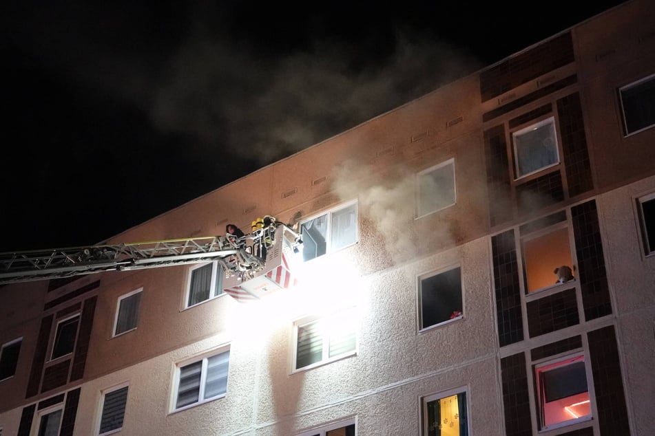 Dramatische Rettungsaktion: Über die Drehleiter holen Feuerwehrleute eine vom Rauch eingeschlossene Familie aus ihrer Wohnung im fünften Geschoss.