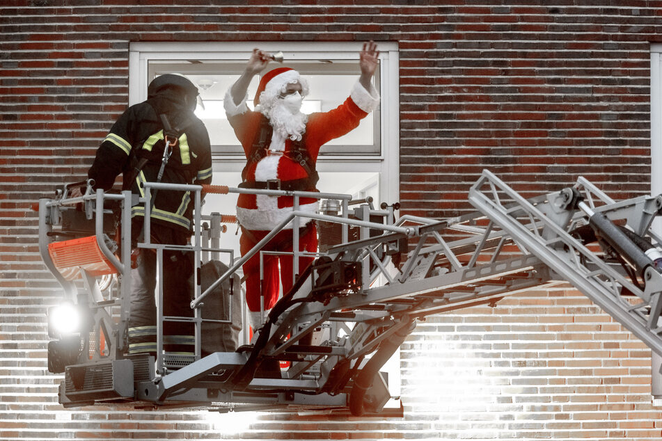 Professor Martin Rupprecht, leitender Oberarzt in der Kinderorthopädie des Altonaer Kinderkrankenhauses, fährt als Weihnachtsmann verkleidet mit Hilfe der Feuerwehr zu einem Fenster des Krankenhauses.