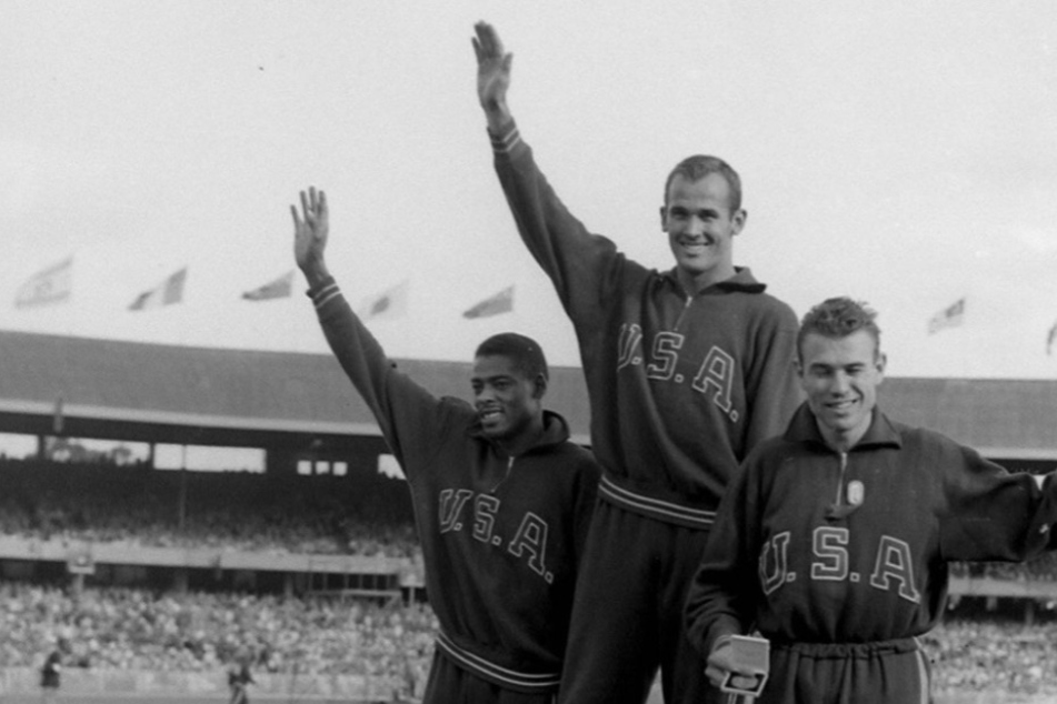 Bobby Morrow 1956 auf dem Treppchen neben Andrew Stanfield (Platz 2) und Walter Baker (Platz 3).