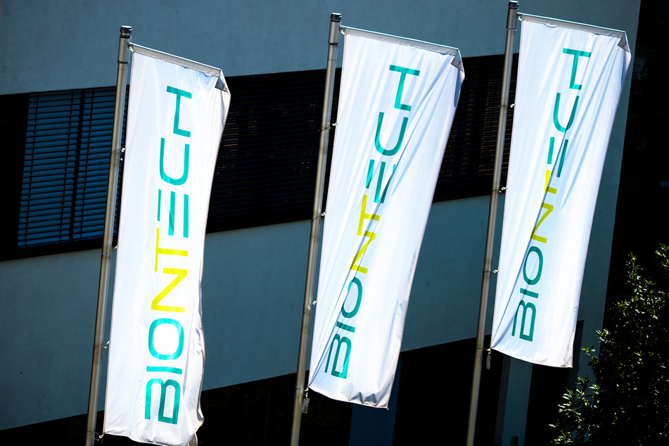 Das Logo des Biotechnologie-Unternehmens "BioNTech" ist auf Fahnen vor der Unternehmenszentrale zu sehen.