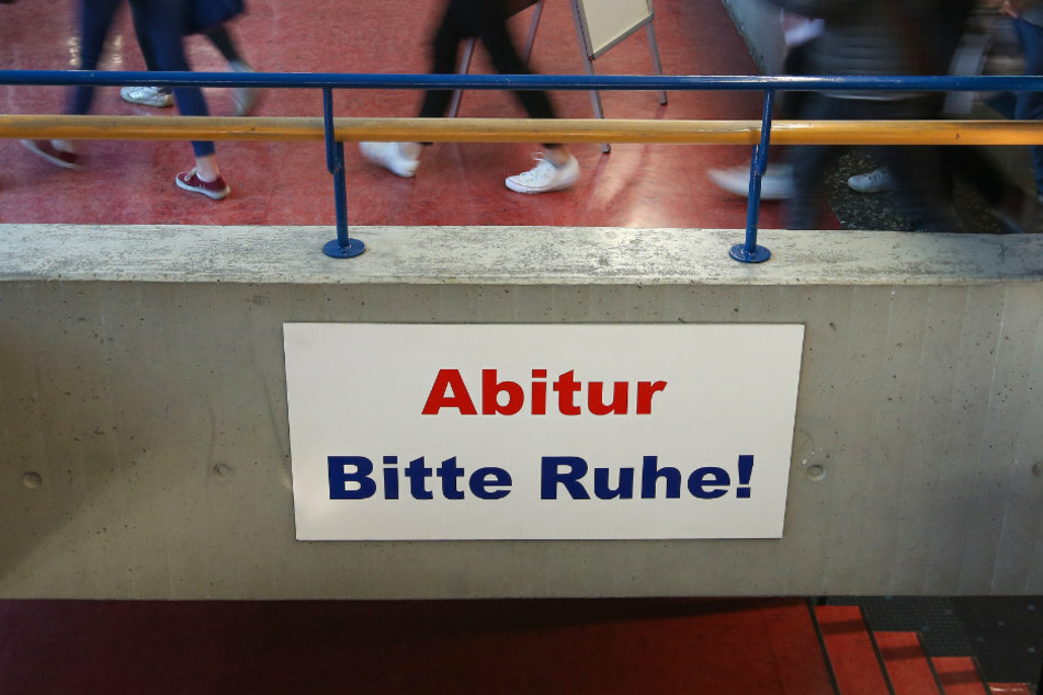 Ein Schild mit der Aufschrift "Abitur Bitte Ruhe!" hängt im Gang eines Gymnasiums.