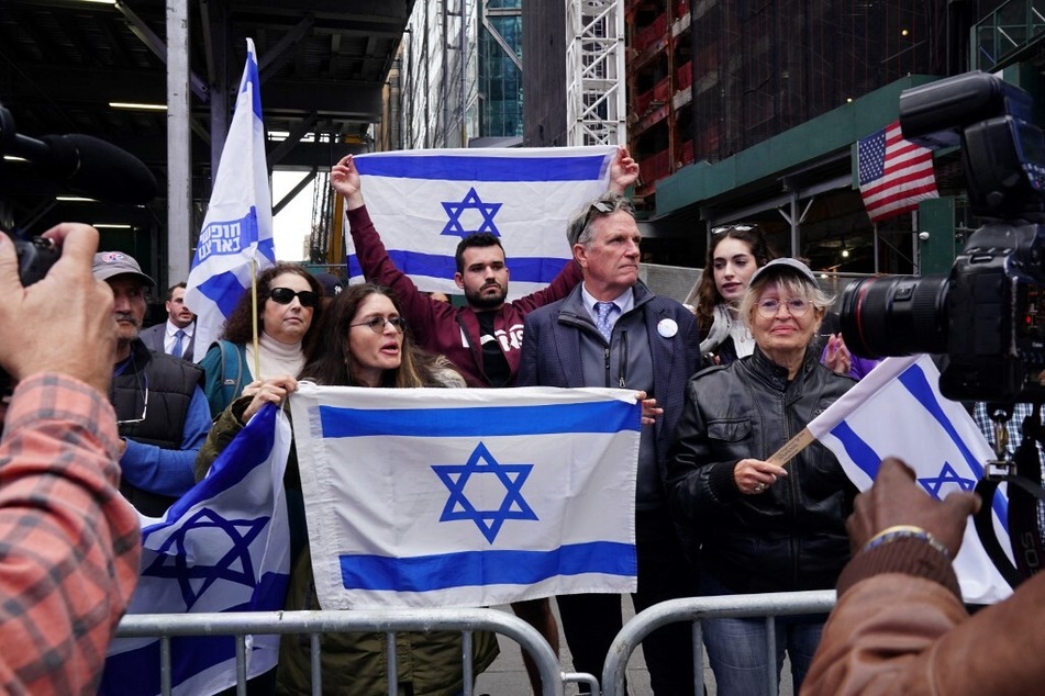 On October 8, 2023, New Yorkers wave Israeli flags in Times Square after a deadly attack by the Palestinian militant group Hamas.