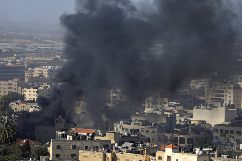 Black smoke rises from the Jenin Palestinian refugee camp during clashes with the Israeli military in the occupied West Bank on Thursday, where at least 14 were killed.