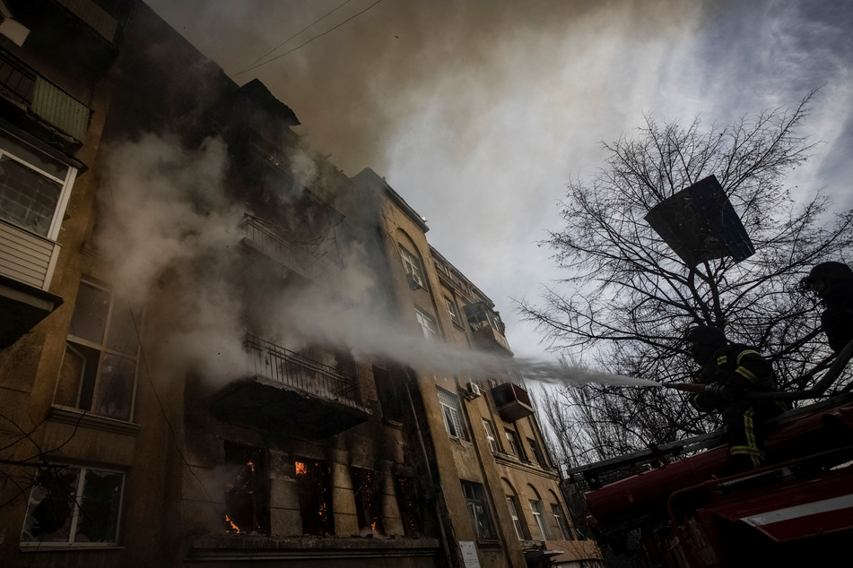 Firefighters in Bakhmut work to put out a fire at a residential building hit by a Russian military strike , as Russia continues its attacks on Ukraine.