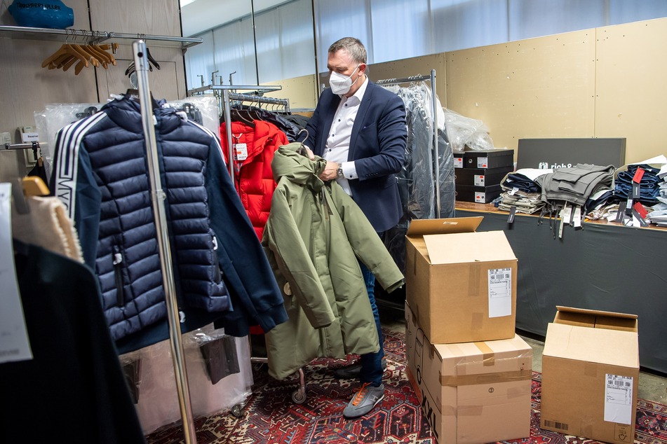 Jens Ristedt sortiert im Lager seines Modehauses die unverkaufte Winterkleidung.