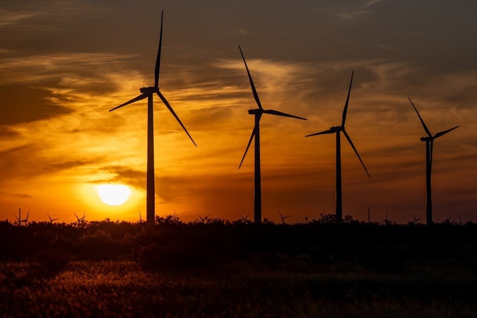 Wind turbines operate in a field at sunrise in Nolan, Texas.