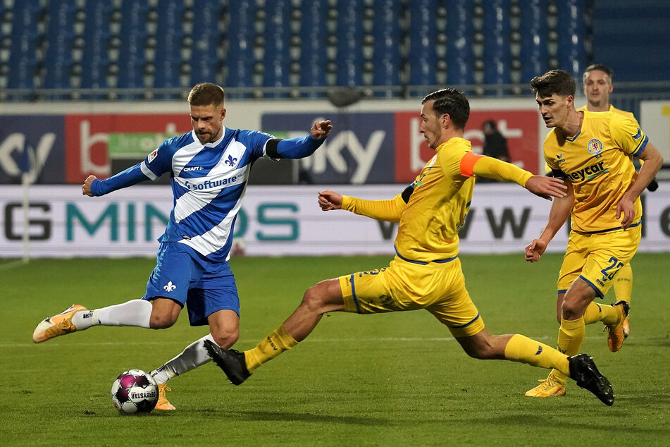 Lilien-Kicker Tobias Kempe (l.) hat es im Zweikampf mit Dominik Wydra (m.) und Danilo Wiebe zu tun.