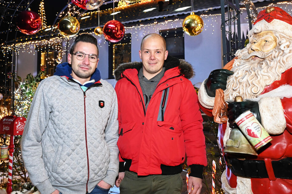 Sascha Bärwald (l.) und Dominik Pieczko stehen vor ihrem Weihnachtshaus im nordhessischen Ahnatal bei Kassel.