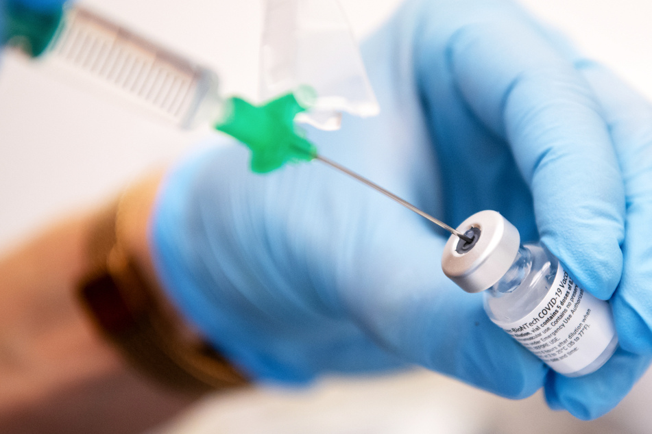 Eine Klinik-Mitarbeiterin zieht den Covid-19 Impfstoff von Biontech/Pfizer für eine Impfung auf eine Spritze.