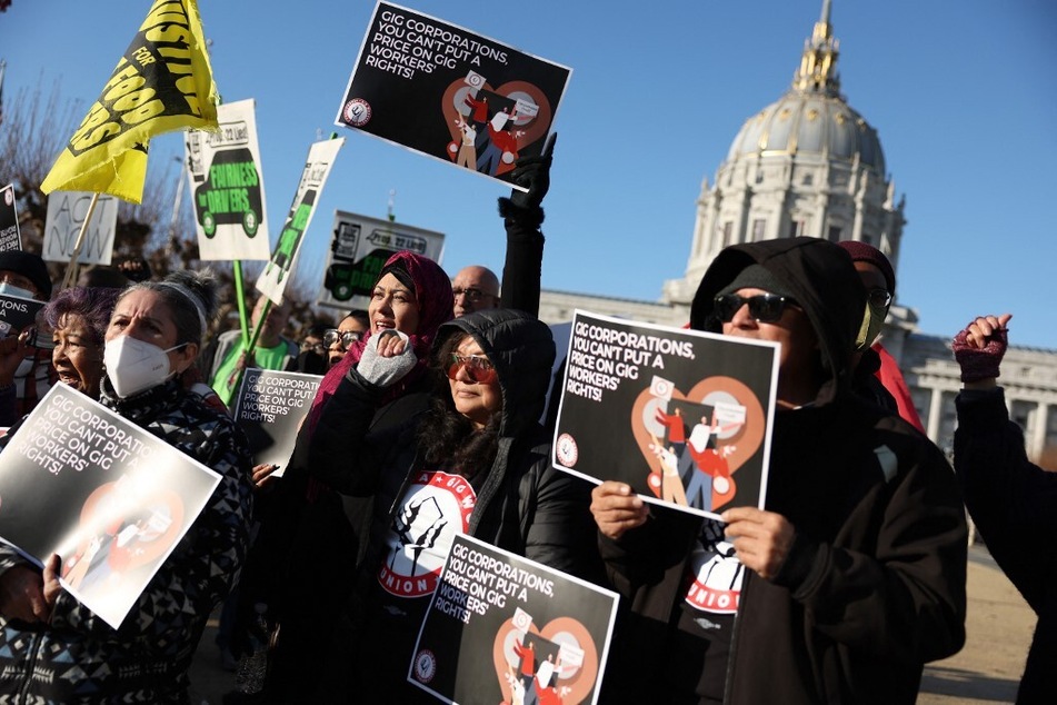 Members of the California Gig Workers Union hold signs during a rally against Proposition 22 outside of the California First Appellate District Court of Appeal in San Francisco.