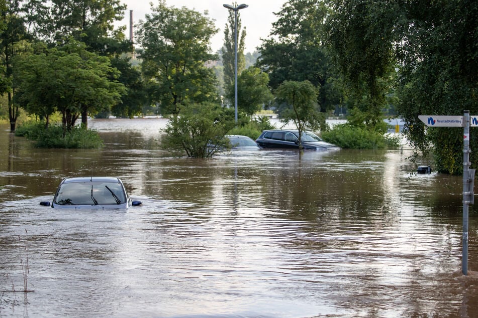 Autos stehen im Hochwasser, nachdem die Aisch im bayrischen Neustadt am Freitag über die Ufer getreten ist.