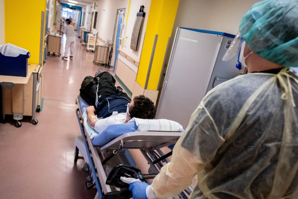 Der Stationsleiter schiebt einen Patienten zur Covid-19-Station des Krankenhauses Bethel Berlin.