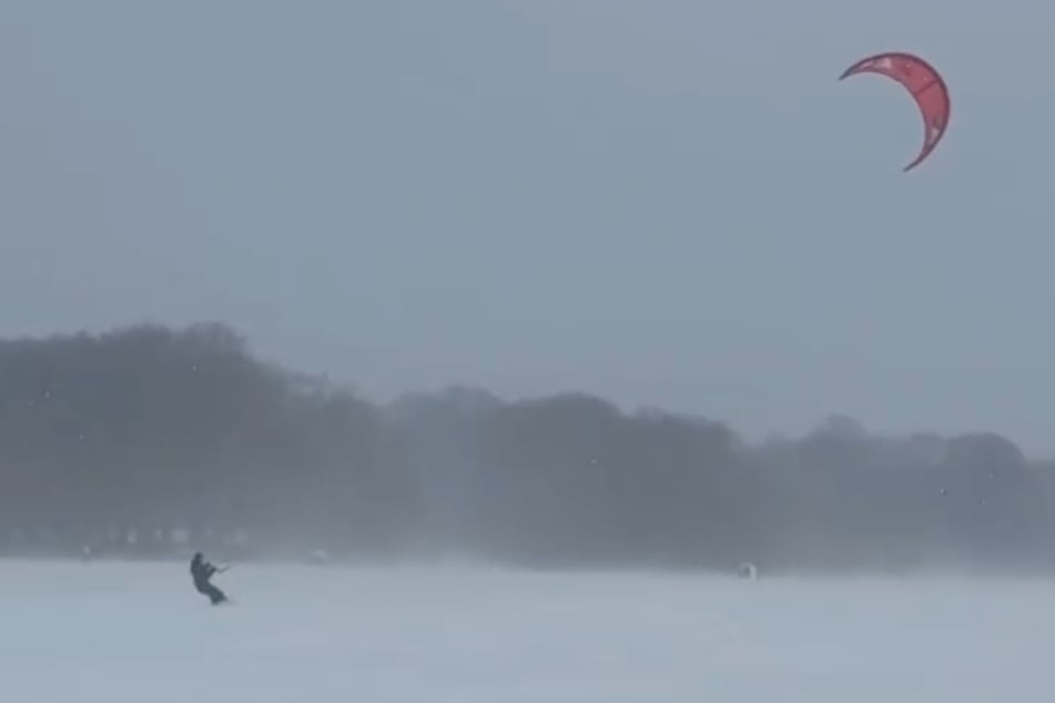 Im Hamburger Stadtpark ließ sich ein Wintersportler vom Wind durch den Schnee ziehen.