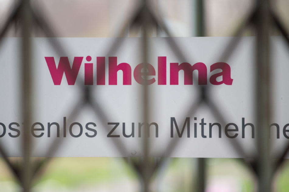 Ein Schriftzug des Zoologisch-Botanischen Gartens Wilhelma ist hinter einem Gittertor zu sehen.