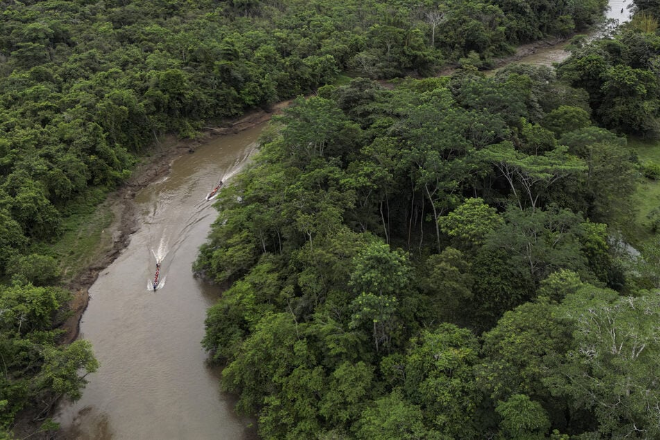 This aerial view shows migrants sailing a boat on their way to the Temporary Reception Centre for Migrants in Lajas Blancas, Panama in the jungle province of Darien on September 26, 2024.