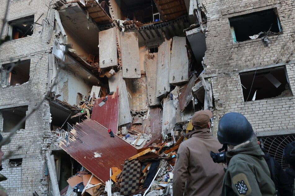 Saporischschja: Nach dem Einschlag einer russischen Rakete in ein Wohnheim arbeiten Rettungskräfte am Schauplatz.