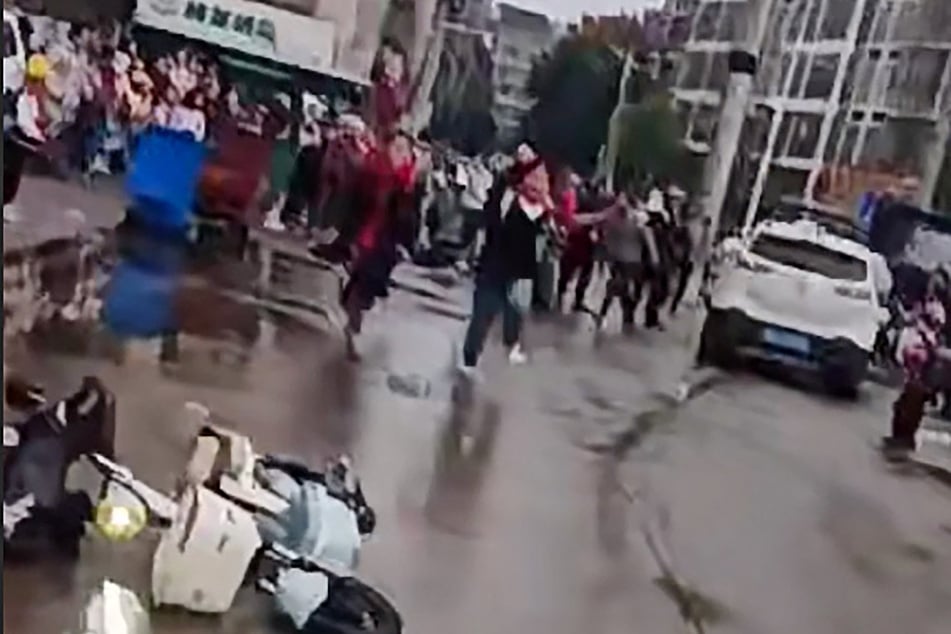 This frame grab taken from video footage circulating on Chinese social media on Tuesday shows the scene where a car crashed outside the Yong'an primary school in Changde, central China's Hunan province, in which "multiple students were injured" according to state-run media.