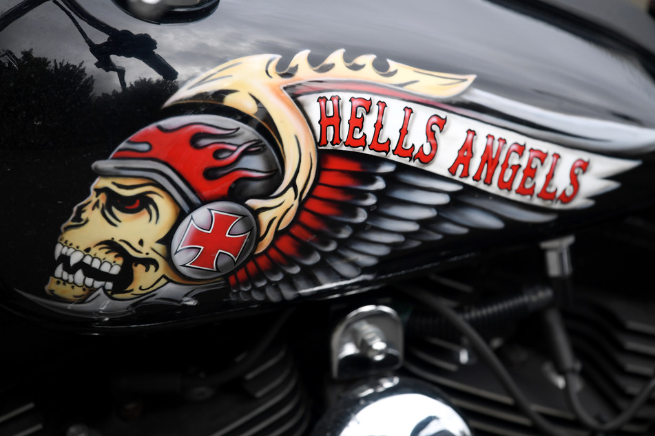 Das Hells Angels-Emblem, ein Totenkopf mit Helm und Flügeln, ist auf dem Tank eines abgestellten Motorrads zu sehen.