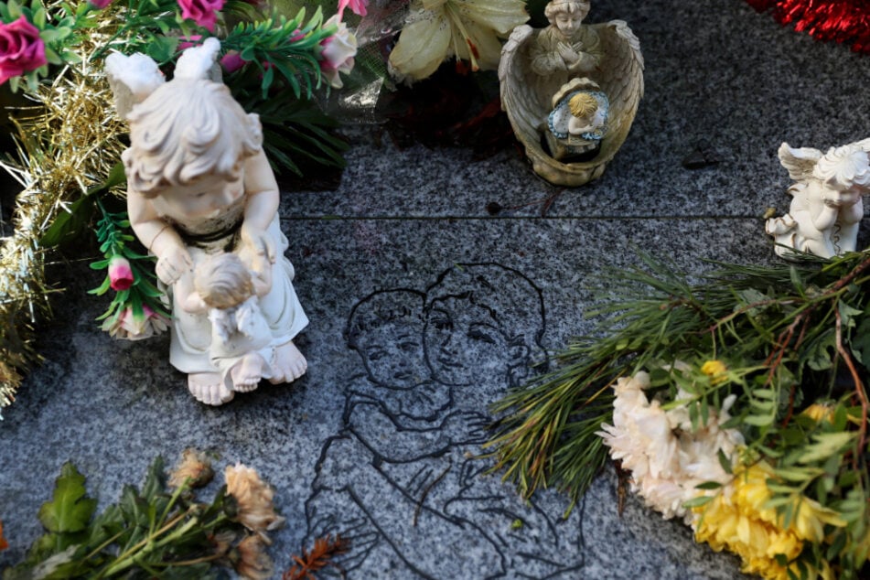 Blumen und Engel-Figuren liegen an einer Gedenkstätte für 222 Kinder aus dem Bethany Mother and Child Home auf dem Friedhof Mount Jerome.